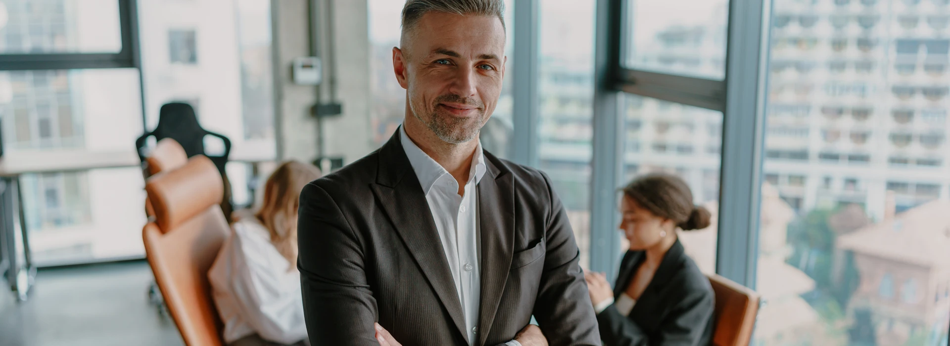 smiling-male-entrepreneur-with-crossed-hands-standing-office-banner smiling-male-entrepreneur-with-crossed-hands-standing-office-banner